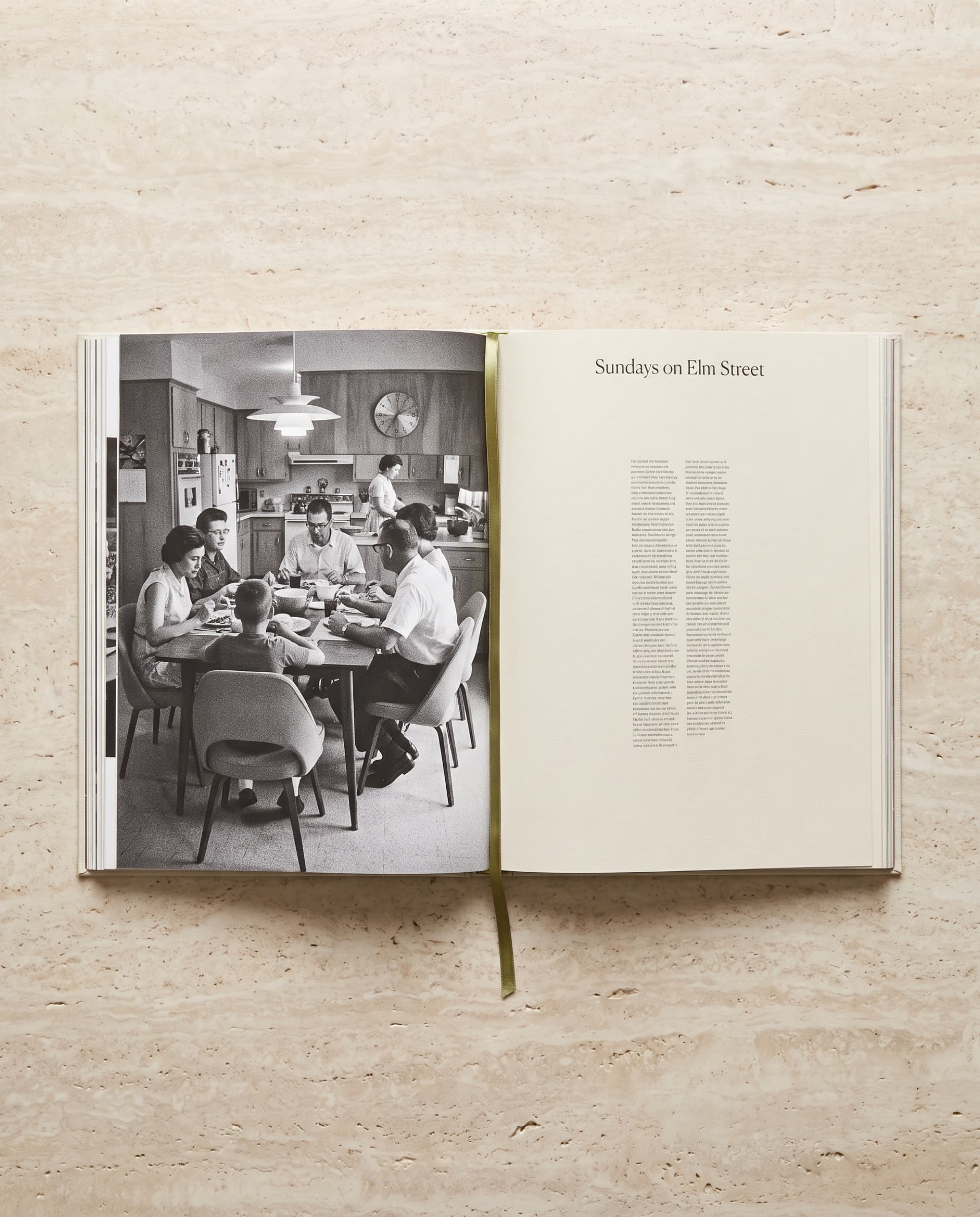 An open book with a black-and-white photograph of a family dinner