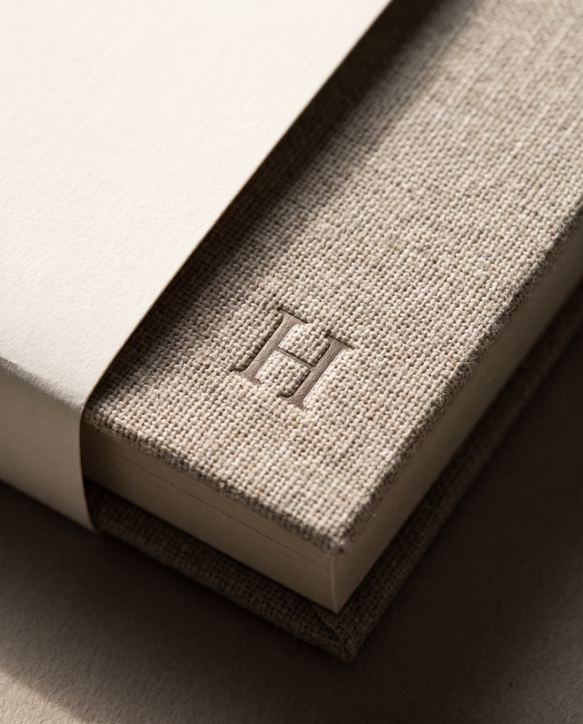 The linen spine of the book with a debossed H monogram